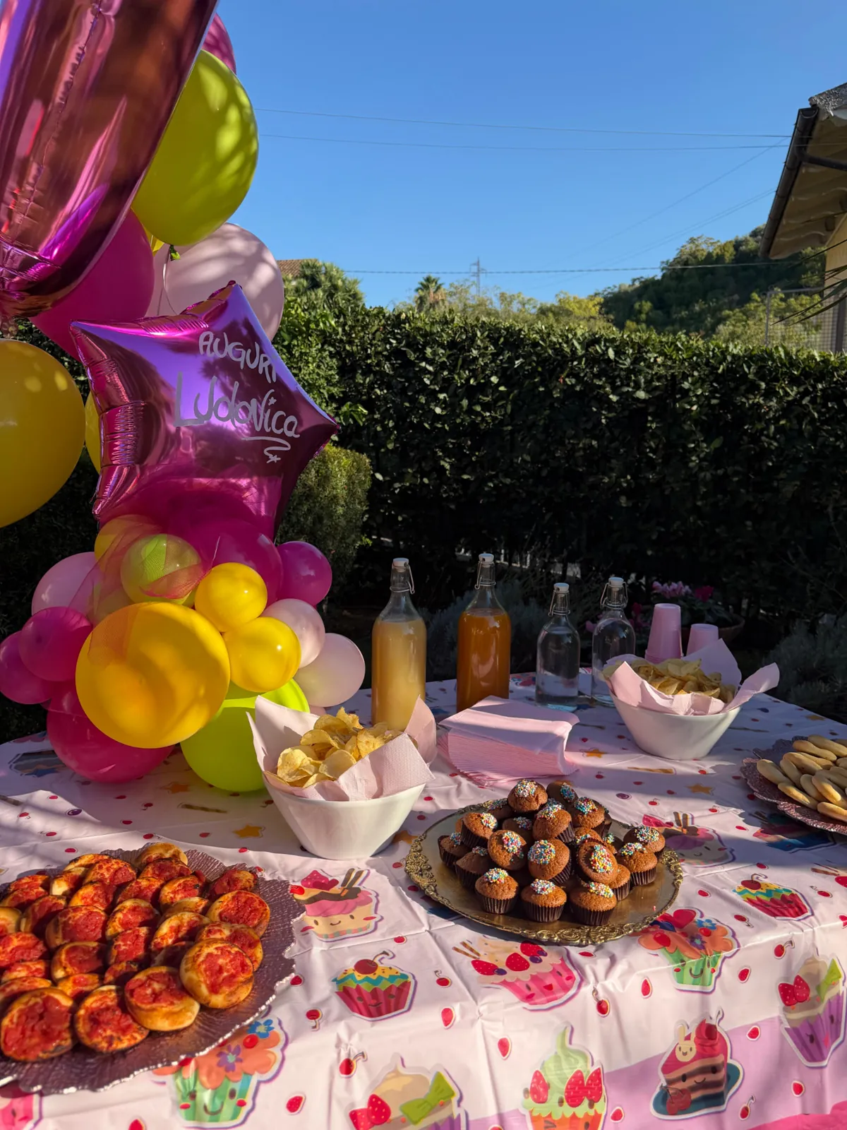 Tavolo della merenda di una festa privata con dolci, salati e palloncini